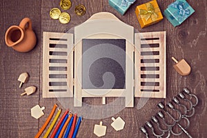 Hanukkah holiday symbols on wooden table with chalkboard. View from above