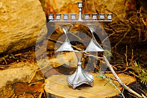 Hanukkah Menorah. Jewish candlestick in style Jewish star Magen David. Background: sawed wood stump and natural stones. Image of