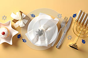 Hanukkah tableware, cutlery, gift boxes, menorah, jelly donut on golden table. Jewish holiday Chanuka concept. Flat lay, top view photo