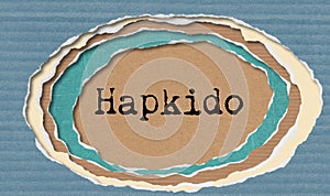 Hapkido - typewritten word in ragged paper hole background Korean martial art- concept tattered illustration