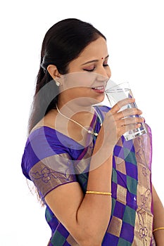 Happ young traditional woman drinking glass of water