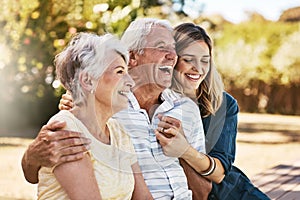 Happiest are hearts that love. a happy young woman spending quality time with her elderly parents outdoors.