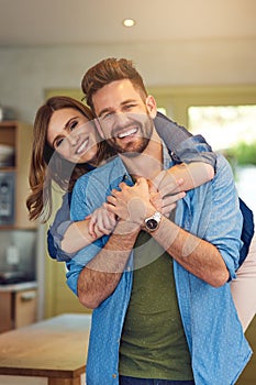 The happiest marriages make the happiest homes. Portrait of a happy young couple embracing at home.