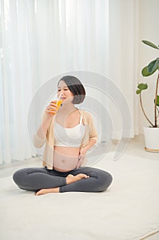 The happiest time for every woman. Fruit and orange juice in the hands of a pregnant woman