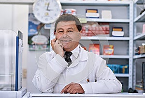 Happily waiting for the next customer. Portrait of a male pharmacist in a pharmacy.