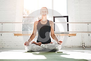 Happines fit woman practicing yoga poses in gym in the mowrning. Female in yoga pose on fitness mat