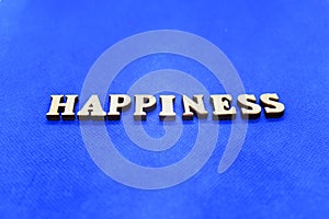 Happines white wooden letters on blue background