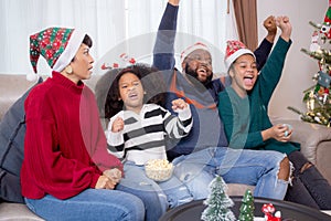 Happiness African family watching movie with excited and fun in the living room for leisure with comfort at home on Christmas day.