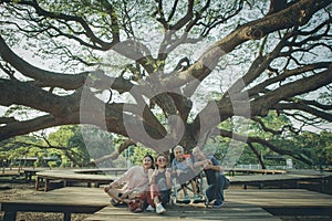 happiness asian family sitting under big raintree