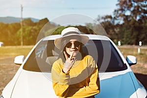 Happiness asian woman showing 2 finger while standing with new car on road,Relax and free time,Happy and smiling