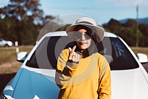 Happiness asian woman showing mini heart shape while standing with new car on road,Happy and smiling,Car insurance concept