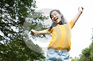 Happiness asian woman standing feel comfortable at park,smiling female teenage with stretching her arms,enjoy breathing fresh air,