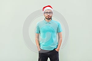 Happiness bearded man in shristmas red hat and black glasses sta