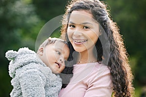 Happiness is a big hug from a small person. Portrait of a mother bonding with her baby son outdoors.