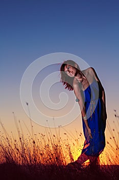 Happiness bliss freedom concept. Beautiful woman enjoying the sunset in the field