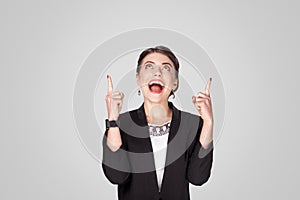 Happiness businesswoman pointing finger up at copy space