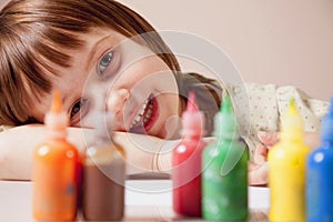 Happiness of child. Little cute girl laughing with coloured paints