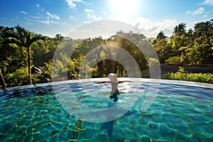 Happiness concept. Woman sunbathing in infinity swimming pool at