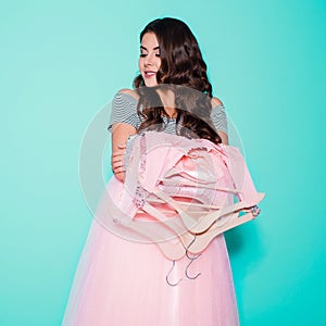 Happiness, consumerism, sale and people concept - smiling young woman holding dresses