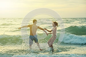 Happiness couple in romantic scene on the beach at sunset. Love and valentine concept