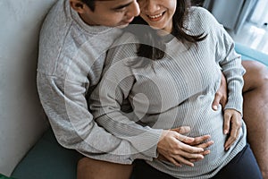 Happiness couples holding the wife`s pregnant stomach