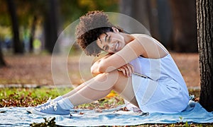 Happiness is... A day in the park. Full length portrait of an attractive young woman smiling happily while sitting in