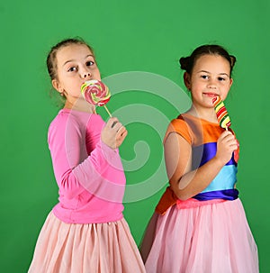 Happiness and dessert concept. Children eat big colorful sweet caramels.