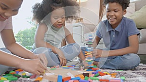 Happiness family with children playing block wood on floor together with fun and relax in the living room at home.