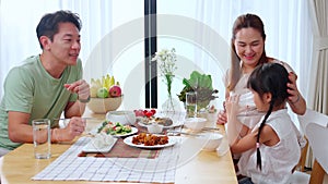 Happiness family with mother and adorable daughter drinking milk or beverage together in the living room.