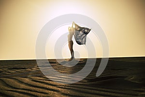 Happiness and freedom concept with woman standing on the sand dunes at the desert beach and play with the wind feeling the nature