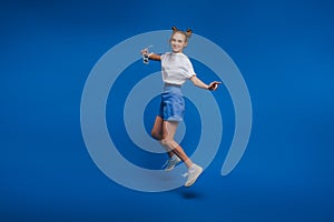 Happiness, freedom, motion and people concept - smiling young woman jumping in air over white background