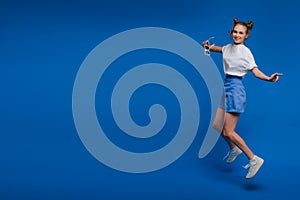 Happiness, freedom, motion and people concept - smiling young woman jumping in air over white background