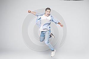 Happiness, freedom, movement and people concept - smiling young man jumping in air isolated on white background