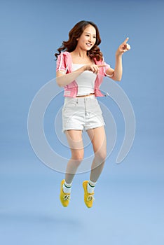 Happiness, freedom, movement and people concept - smiling young woman jumping in air