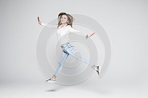 Happiness, freedom, power, motion and people concept - smiling young woman jumping in air with raised fists over white background