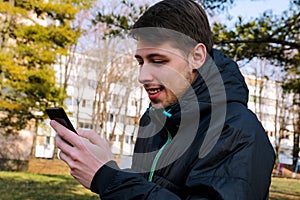 Happiness guy with a smart phone using in the park