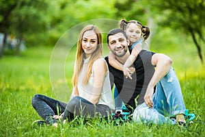 Happiness and harmony in family life. Happy family concept. Young mother and father with their daughter in the park. Happy family