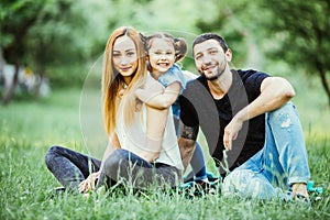 Happiness and harmony in family life. Happy family concept. Young mother and father with their daughter in the park. Happy family