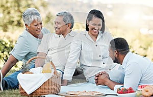 Happiness is having a large, loving family. a family enjoying a picnic in a park.