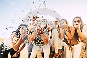 Happiness and joyful concept - group of happy women people celebrate. all together blowing confetti and having fun - new year eve