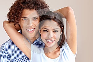 Happiness and love. Studio portrait of a cheerful young ethnic couple embracing and smiling at the camera.
