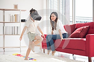 Happiness mother looking at her little daughter play VR game for entertain