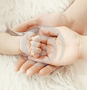 Happiness parents! closeup hand baby in hands mother and father