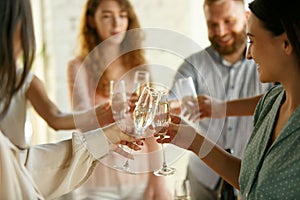 People clinking glasses with wine or champagne. Happy cheerful friends celebrate holidays, meeting. Close up shot of