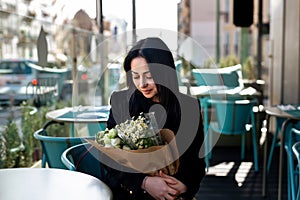 Happiness, romance and beauty concept. Cheerful gorgeous brunette young woman holding bouquet of flowers and smiling.