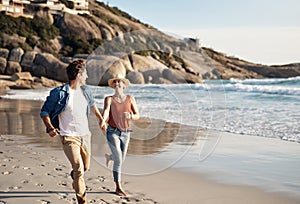 Happiness is sand between your toes and love by your side. a middle aged couple spending the day at the beach.