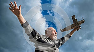 happiness of senior retired man. mature man at retirement. old man on sky background with toy plane