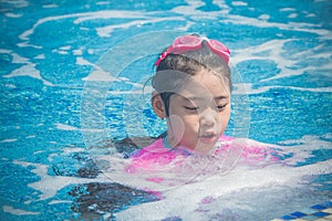 Happiness and Smiling Asian cute little girl has feeling funny and enjoy in swimming pool.