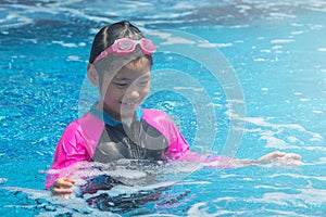 Happiness and smiling Asian cute little girl has feeling funny and enjoy in swimming pool.