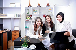 Happiness of three young businesswomen discussing their new job